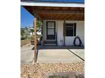 Inviting front entrance with a covered porch and neutral color scheme at 6357 Partridge Ave, Englewood, FL 34224