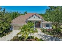 Elegant single-story home with a clay tile roof, manicured landscaping, and a paved driveway at 6633 The Masters Ave, Lakewood Ranch, FL 34202