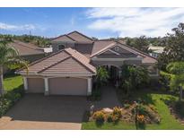Charming home featuring a clay tile roof, a two-car garage, and beautifully landscaped front yard at 6951 Scrub Jay Dr, Sarasota, FL 34241