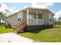 Inviting exterior of home with charming porch and well-maintained lawn at 8226 Sweden Blvd, Punta Gorda, FL 33982
