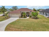 Well-maintained single-story home with a manicured lawn, a two-car garage, and beautiful landscaping at 9012 Province St, Sarasota, FL 34240