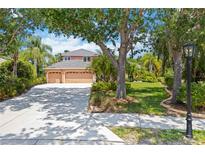 Charming two-story home with a three-car garage and a well-manicured lawn in a lush, green setting at 9915 Old Hyde Park Pl, Bradenton, FL 34202