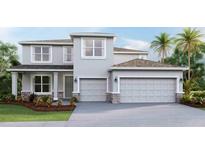 Two story home with a three car garage and professionally landscaped yard, as seen on a sunny day at 10708 Tippecanoe Pl, Parrish, FL 34219