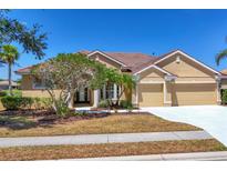 Charming one-story home with a red tile roof, well-manicured landscaping, and a two-car garage at 246 Petrel Trl, Bradenton, FL 34212