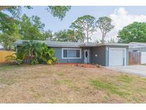 Charming single-story home featuring mature trees, well-maintained landscaping, and a cozy front porch at 301 89Th Ne Ave, St Petersburg, FL 33702