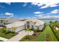 Stunning exterior elevation with manicured lawn, beautiful landscaping, and a large three-car garage at 508 Blue Shell Loop, Sarasota, FL 34240