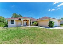 Charming single-story home featuring a well-manicured lawn, red roof, and inviting front entrance at 5168 Cillette Ave, North Port, FL 34288