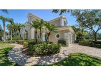 Beautiful exterior showcasing lush landscaping, complemented by a paver walkway and a charming, light-colored facade at 5283 Descanso Ct # 101B18, Sarasota, FL 34238