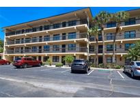 Condominium exterior featuring multiple balconies, parking, and palm trees at 625 30Th W Ave # G210, Bradenton, FL 34205