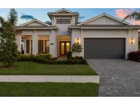 Beautiful single-story home with a well manicured lawn, a gray roof, and a gray two car garage at 8195 Redonda Loop, Lakewood Ranch, FL 34202