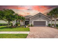 Charming single-story home featuring a brick driveway, landscaped front yard, and well-maintained lawn at 8713 Mangilli Rd, Sarasota, FL 34238