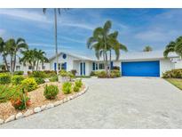 Charming single-story home with colorful landscaping, a blue garage door, and well-maintained exterior at 10108 Kingfisher E Rd, Bradenton, FL 34209