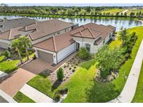 Beautiful single Gathering home with a tile roof, brick driveway and meticulously manicured front lawn at 10819 Wicker Park Pl, Palmetto, FL 34221