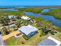 An aerial view of the charming home showcasing a waterfront location and lush landscaping at 1680 Lemon Bay Dr, Venice, FL 34293