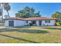 Charming single-story home with a terra cotta tile roof and lush front lawn at 2301 Cass St, Sarasota, FL 34231