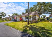 Charming villa with stone accents, carport, and beautifully manicured lawn at 2531 Riverbluff Pkwy # V181, Sarasota, FL 34231