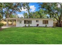 Charming single-story home featuring a well-manicured lawn, a covered carport, and a freshly painted exterior at 2535 Floyd St, Sarasota, FL 34239