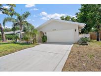 Charming single Gathering home boasting a well-manicured lawn, spacious driveway, and a two-car garage at 3370 Harbor Lake Dr, Largo, FL 33770