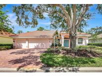 Charming single-story home featuring a tile roof, brick driveway, and mature landscaping at 4730 Old Farm Rd, Sarasota, FL 34233