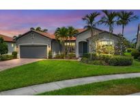 Charming single-story home with lush lawn, mature landscaping, and a terracotta tile roof at 5923 Snowy Egret Dr, Sarasota, FL 34238