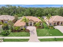 Beautiful single-story home featuring lush landscaping, a brick-paved walkway, and a tile roof at 7659 Trillium Blvd, Sarasota, FL 34241