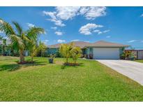 Charming home with a well manicured lawn, lush landscaping, and a two car garage in a lovely neighborhood at 9321 New Martinsville Ave, Englewood, FL 34224