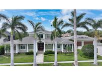 Inviting home with lush landscaping, palm trees, and charming front porch, creating a welcoming curb appeal at 1910 Datura St, Sarasota, FL 34239