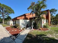 Charming townhouse with desert landscaping and a walkway leading to the front door at 2058 Sunset Point Rd # 11, Clearwater, FL 33765