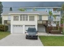 Two-story home featuring a two car garage, wood stairs, and a well-manicured lawn at 300 N 22Nd St, Bradenton Beach, FL 34217
