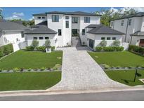 Stunning new construction home featuring a modern design, manicured lawn, and elegant paver driveway at 4815 W Sunset Blvd, Tampa, FL 33629