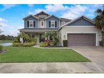 Charming two-story home with a well-manicured lawn and lush landscaping at 6001 Anise Dr, Sarasota, FL 34238