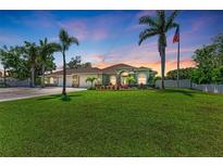 Charming home featuring a well-manicured lawn, palm trees, and a stately American flag at 7420 Tuttle Ave, Sarasota, FL 34243