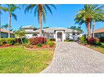 Inviting single story home with a paver driveway, lush landscaping, and classic architecture in a desirable neighborhood at 7582 Camden Harbour Dr, Bradenton, FL 34212