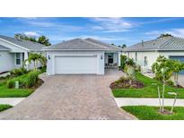 Charming single-story home featuring a brick driveway, two-car garage, and well-maintained landscaping at 10394 Abaco Falls Dr, Englewood, FL 34223
