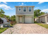 Two-story home featuring a charming front entrance, brick driveway, attached garage, and neutral paint colors at 1122 42Nd E Ter, Bradenton, FL 34208