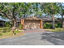 Charming home with mature trees, a two-car garage, and a neatly landscaped front yard at 1308 Willow Oak Cir, Bradenton, FL 34209