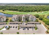 Aerial view of condo complex with mature landscaping, covered parking, pond and golf course views at 17510 Gawthrop Dr # 208, Bradenton, FL 34211