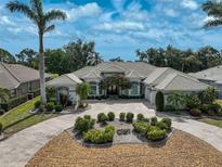 Stunning home featuring lush landscaping, a circular driveway, and a beautiful tile roof at 2111 Muskogee Trl, Nokomis, FL 34275