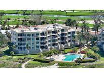 Multi-story condominium features beautiful landscaping, a pool, and golf course views at 2185 Gulf Of Mexico Dr # 243, Longboat Key, FL 34228