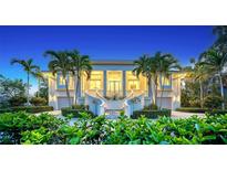 Elegant home exterior featuring a grand entrance, palm trees, and lush landscaping at 244 Cedar Park Cir, Sarasota, FL 34242