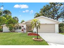 Charming single-story home with a well-manicured lawn, mature trees, and a two-car garage at 2720 Pinewood Ct, Clearwater, FL 33761