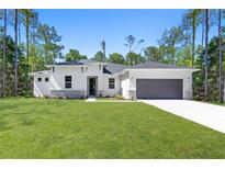 Beautiful single-story home featuring stone accents, a two-car garage, and a manicured lawn at 4008 Antelope Ter, North Port, FL 34286