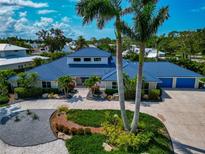 Stunning home with blue tile roof, meticulous landscaping, and spacious circular driveway at 4307 Camino Real, Sarasota, FL 34231