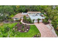 Beautiful home showcasing lush landscaping, brick driveway, and charming curb appeal at 6343 Hollywood Blvd, Sarasota, FL 34231