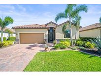 Charming single-story home with a tile roof, brick driveway, and lush tropical landscaping at 7120 Quiet Creek Dr, Bradenton, FL 34212