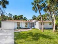 Charming single-story home with palm trees, a brick facade, and a well-manicured lawn at 734 Canal Rd, Sarasota, FL 34242