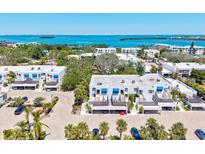 Bright aerial view of a condo complex showcasing the beautiful blue waterfront views in the distance at 750 Bayport Way # 750, Longboat Key, FL 34228