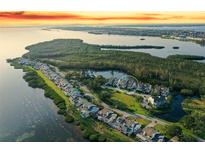Breathtaking aerial view of waterfront homes with lush greenery and tranquil bay, highlighted at sunset at 111 Tidy Island Blvd # 111, Bradenton, FL 34210