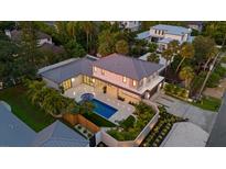 Aerial view showcasing a modern home with a large pool, lush landscaping, and expansive outdoor living areas at 1559 Bay Rd, Sarasota, FL 34239