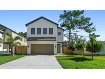 Modern two-story home with a two-car garage, manicured lawn, and well-maintained landscaping at 2249 Oak Terrace Ter, Sarasota, FL 34231